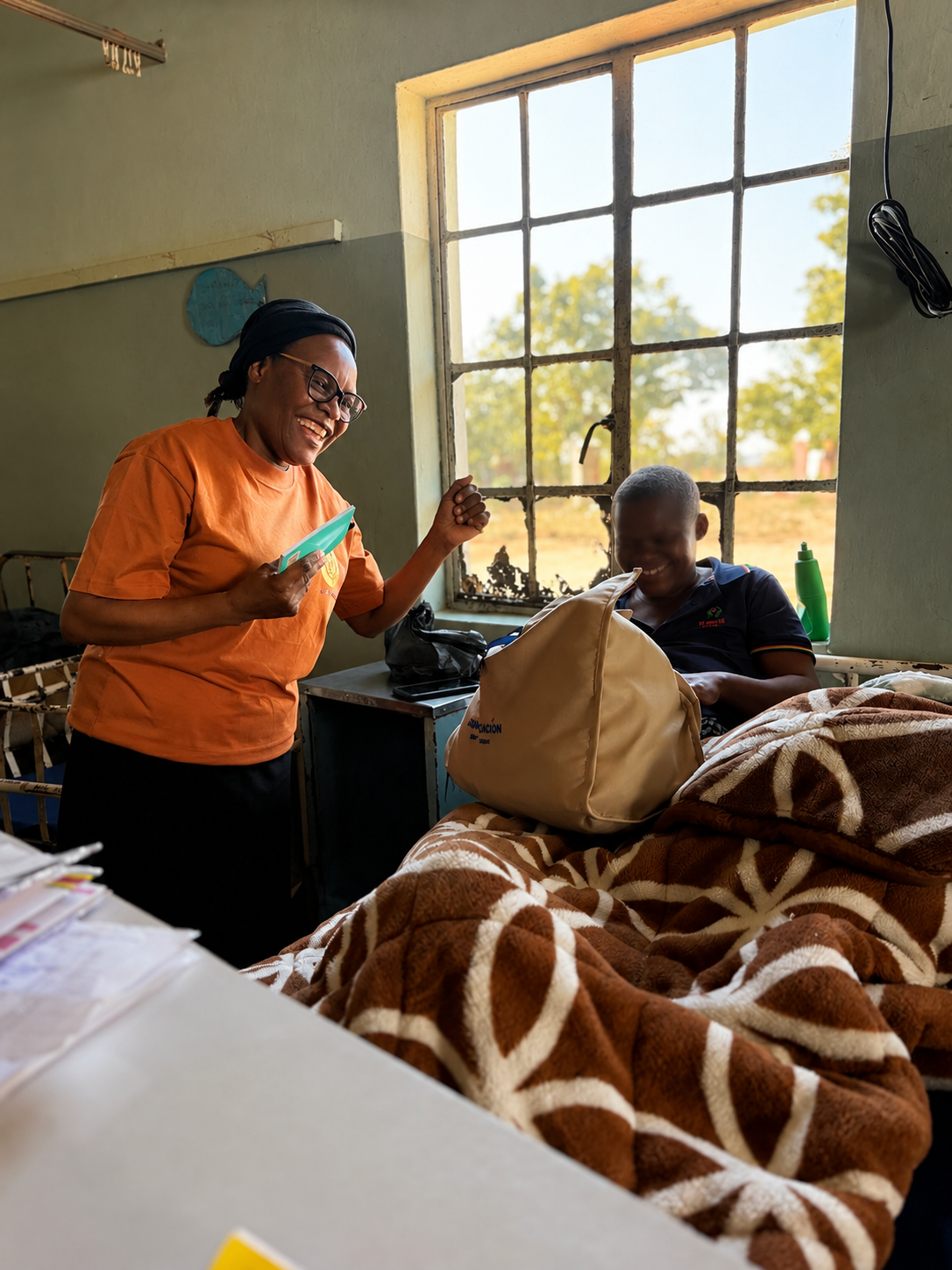 A Lumera volunteer sharing a Grace care kit with a mother at Makumbe District Hospital